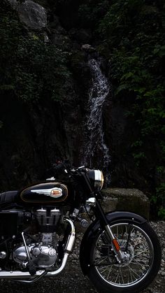 a motorcycle parked in front of a waterfall