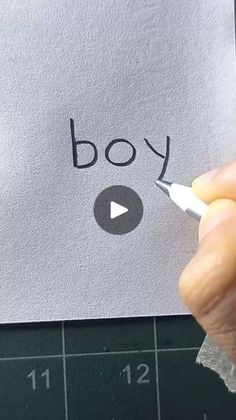 someone is writing the word boy on a piece of paper