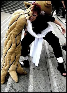 a person in a cat costume sitting next to a stuffed animal