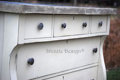 a white dresser with knobs and drawers on it's sides in the yard