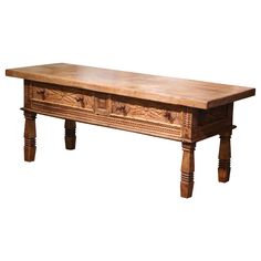 an old wooden table with two drawers on one side and three legs at the bottom