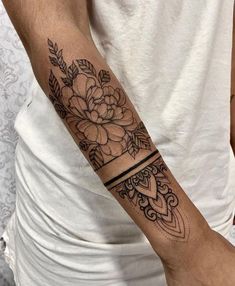 a man's arm with a flower tattoo on it and an arrow in the middle