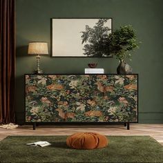 a living room with green walls and an animal print cabinet next to a rug on the floor