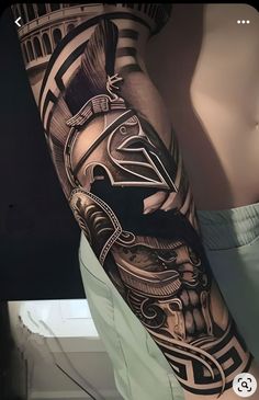 a man's arm with a black and grey tattoo on it