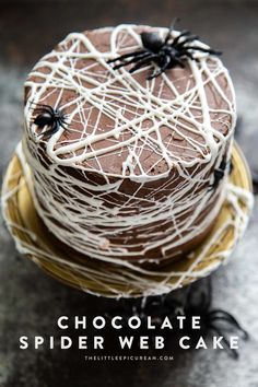 chocolate cake decorated with white icing and spider webs on top, sitting on a yellow plate