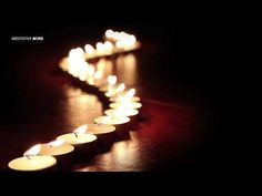 many lit candles are lined up in the shape of a long line on a table