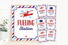 a red, white and blue poster with the words fueling station on it next to a potted plant