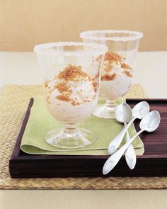 three desserts are sitting on a tray with spoons