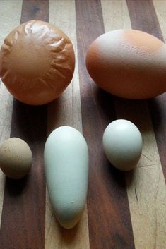 eggs and an egg shell on a wooden table with one brown, one blue in the middle