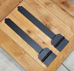 three pieces of black metal sitting on top of a wooden table