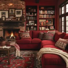 a living room with red couches and bookshelves in it's corner