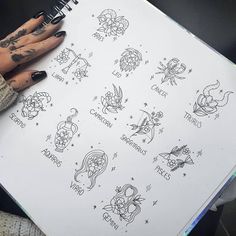 a person holding a notebook with tattoos on it