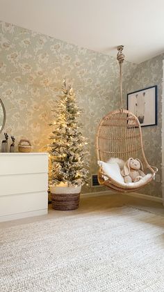 a room with a christmas tree and a hanging chair