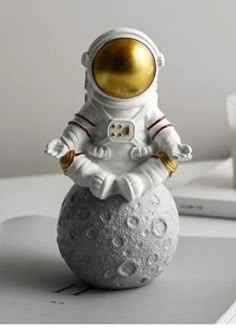 an astronaut figurine sitting on top of a rock