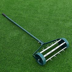 a lawn mower laying on the ground with spikes sticking out of it's sides