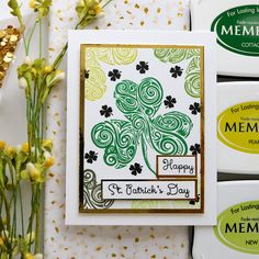 some cards and flowers on a table with gold confetti around them for st patrick's day