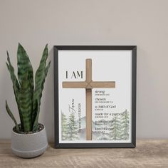 a cross with the words i am on it next to a potted plant and a framed photograph