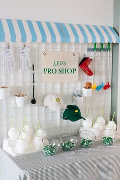 a table topped with lots of white and green items next to a sign that says leo's pro shop