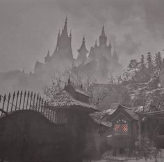 a black and white photo of an old town in the snow with fog over it