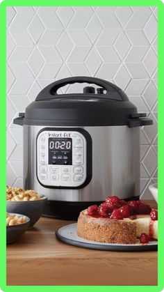 an instant pot with cheesecake and berries on the side, next to a digital pressure cooker