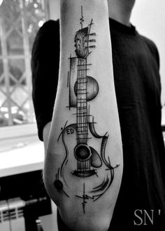 a man with a guitar tattoo on his arm