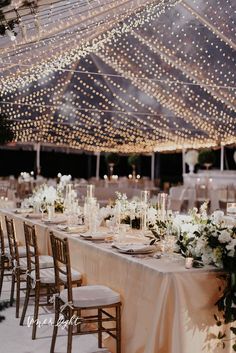 the tables are set up with white flowers and greenery for an elegant wedding reception