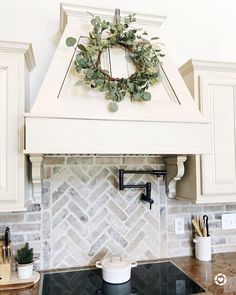 a kitchen stove top with a wreath on it's mantle above the rangetop