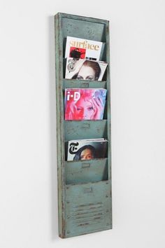 an old wooden book shelf with magazines on it's sides, hanging from the wall