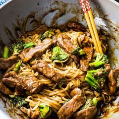 beef and broccoli stir fry in a bowl with chopsticks