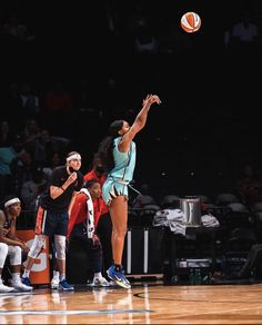 a woman jumping up to hit a basketball