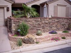 a stone wall in front of a house