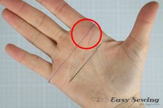 a person's hand with a needle sticking out of the middle of their palm