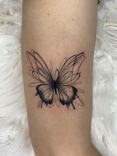 a black and white butterfly tattoo on the right leg, with lines coming out of it