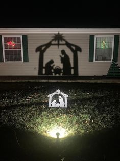 the shadow of a manger scene is cast on the lawn in front of a house