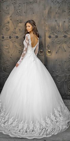 a woman in a white wedding dress is posing for the camera with her back to the camera