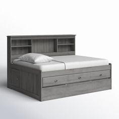 a bed with two drawers underneath it and a white pillow on the bottom one side