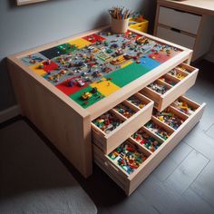 a child's table with legos on it and drawers underneath the table top