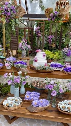 a table topped with lots of cakes and flowers