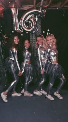 a group of women standing next to each other in front of a number six sign