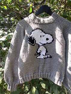 a sweater with a cartoon character on it hanging from a tree