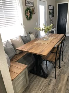 a wooden table sitting in front of a window on top of a hard wood floor