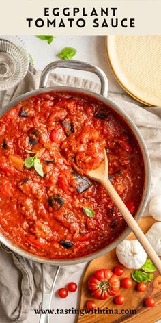 a pan filled with tomato sauce next to garlic and tomatoes