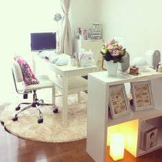 a room with a desk, chair and computer on top of the table in front of a window