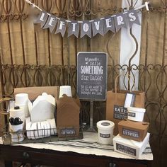 a table topped with lots of different types of soaps and lotions next to a sign