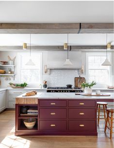 a kitchen with an island, stove and sink in the center is surrounded by wooden flooring