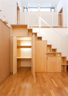 an empty room with wooden stairs and white walls