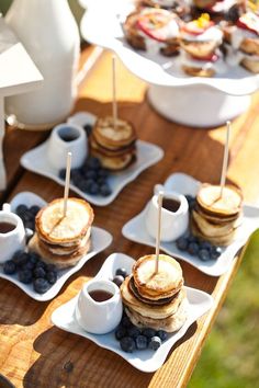 pancakes and blueberries are arranged on small plates