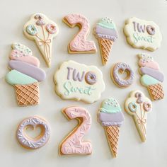 decorated cookies are arranged in the shape of numbers and ice cream cones with frosting on them