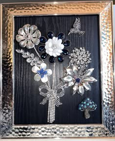 there are many different brooches in the picture frame on the wall, including flowers and butterflies