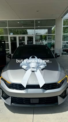 a silver car with a white bow on it